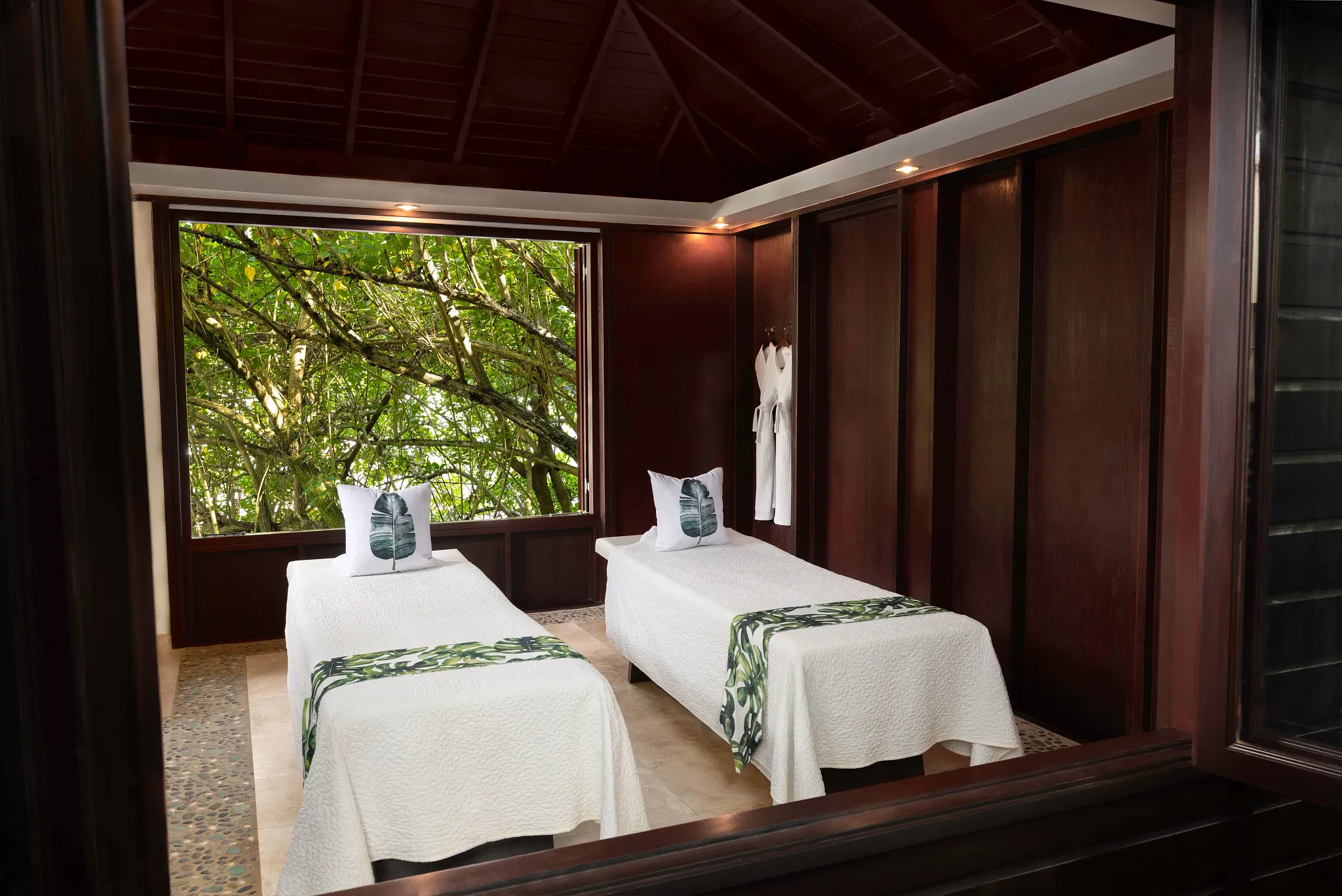Couples massage cabin with twin treatment beds overlooking tropical greenery at Zoëtry Marigot Bay St. Lucia.