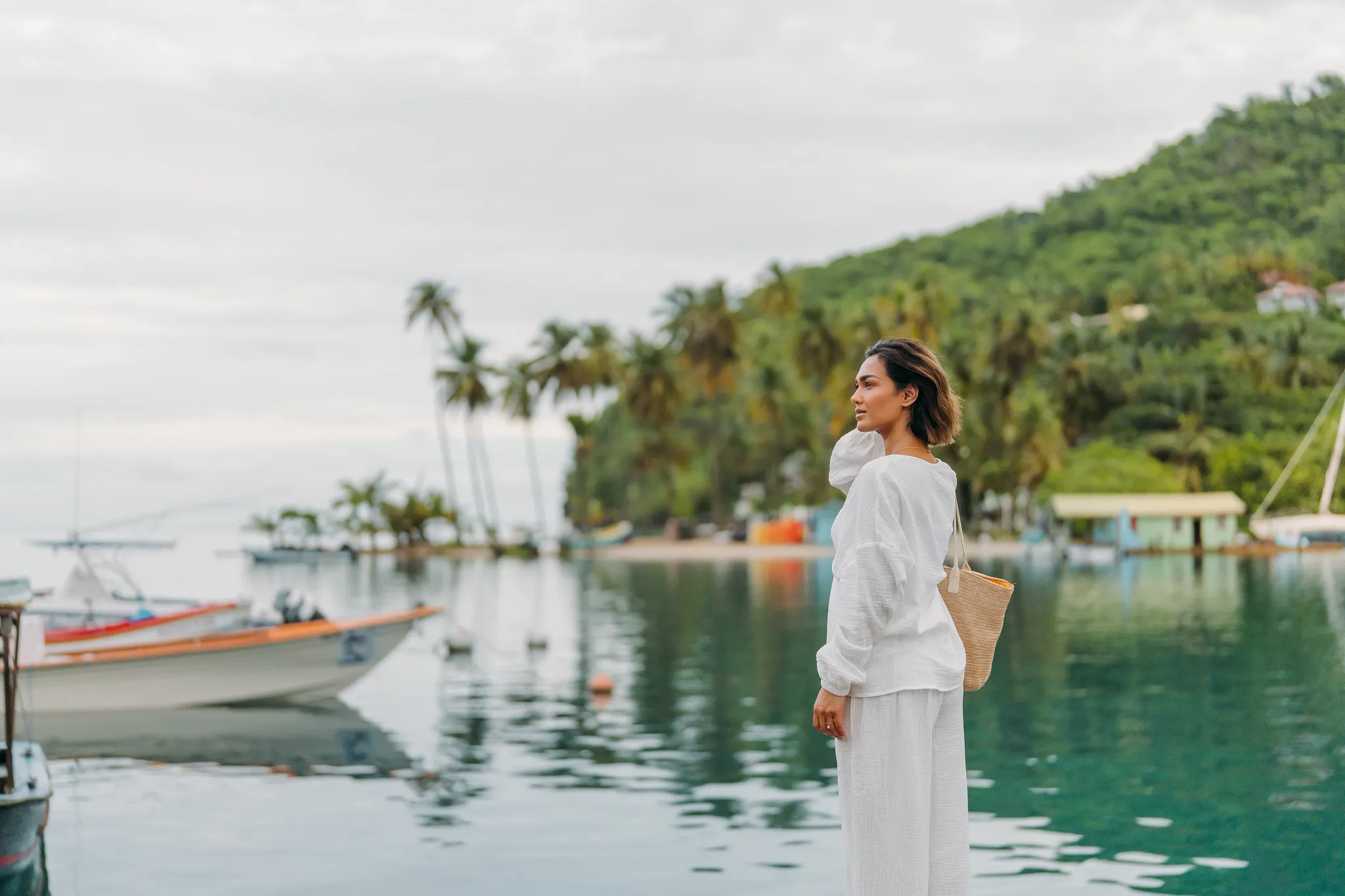 Woman overlooking the calm waters and anchored boats at Marigot Bay near Zoëtry Marigot Bay St. Lucia.