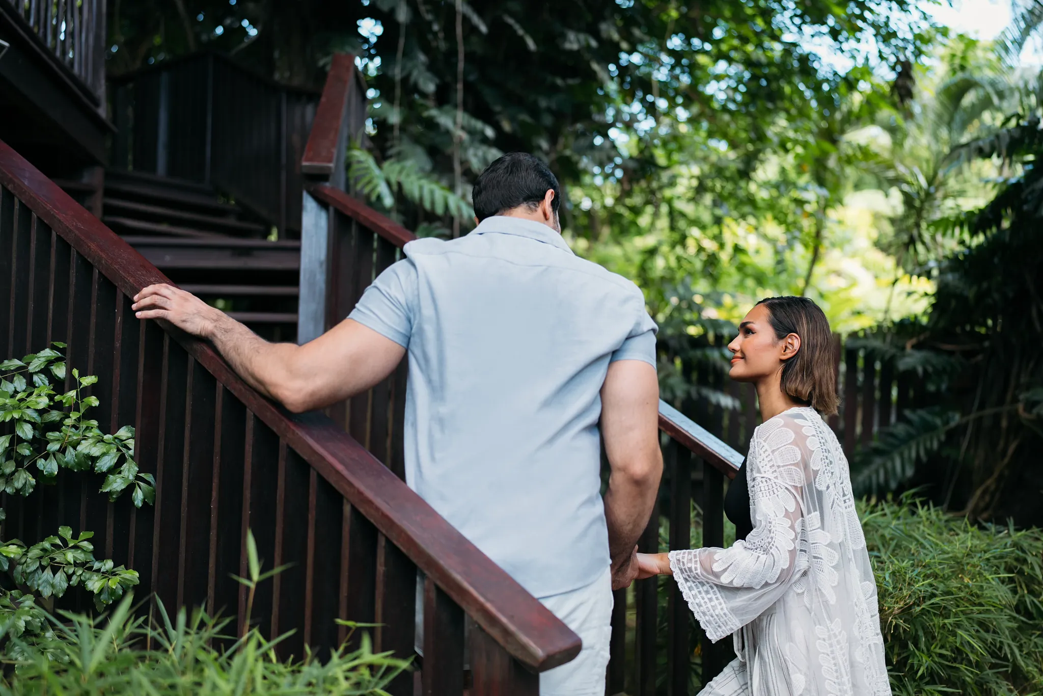 Couple walking up wooden stairs toward a treehouse pavilion at Zoëtry Marigot Bay St. Lucia.